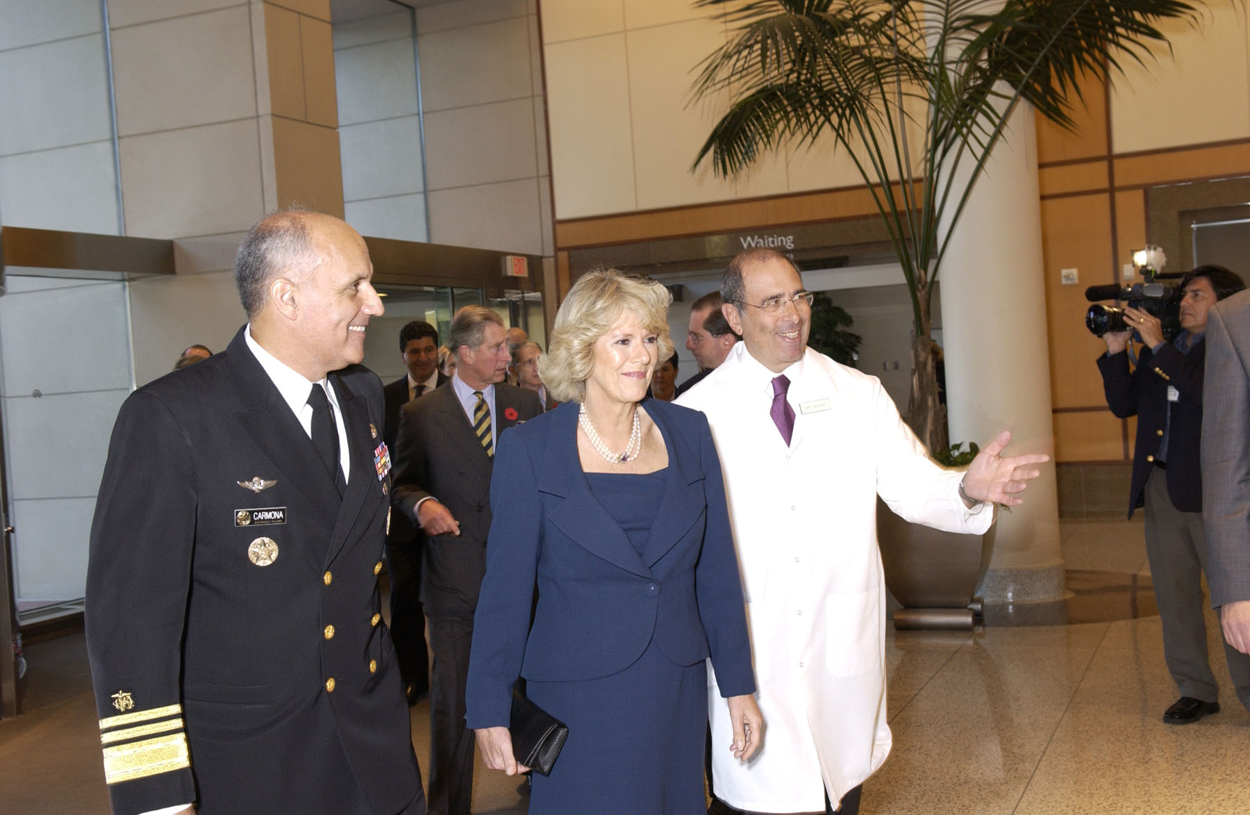 The Duchess of Cornwall, followed by the Prince of Wales, is welcomed to the Clinical Center by Surgeon General Richard H. Carmona (left) and CC Director John I. Gallin (right).
