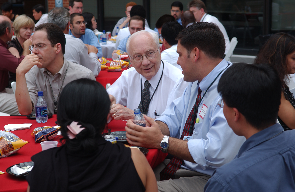 Picture of Dr. John Bennett (NIAID), director, ACGME Infectious Diseases fellowship, speaking with fellows at the reception.