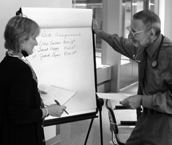 Photo of Ginnie Daine, Nursing, and Dr. Fred Gill, chief, Internal Medicine Consult Service, assist in admitting patients at the Clinical Center.