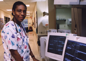 picture of Allison McLean standing at a computer workstation in the critical care unit