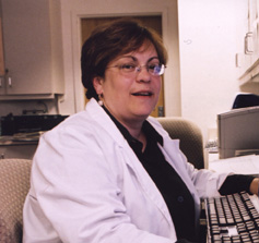picture of Kathy Feigenbaum sitting at her computer workstation