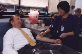 photo of Secretary Thompson in the blood bank preparing to donate blood. 