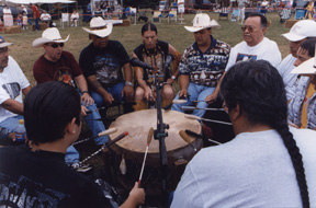 photo of native american indians sitting in a circle playing a drum