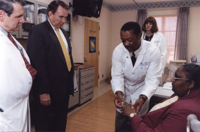 photo of Secretary Thompson visiting with Ainsline Crawford, a patient at the clinical Center 