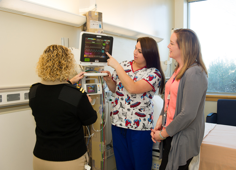 Nurses Lee Ann Keener, Kelly White and Alex Classen view the features of a new pediatric bedside monitor