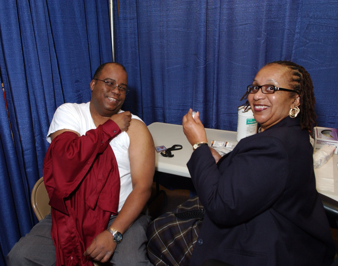 Wayne Randolph (left), medical arts, receives his flu vaccine shot from OMS nurse manager Angela Porter.