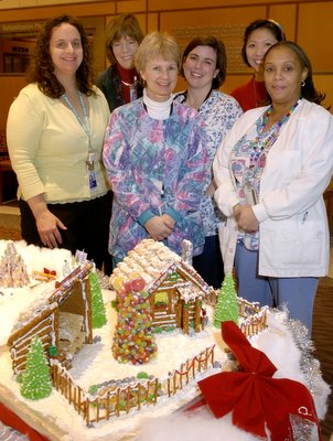 2nd place (l to r) Ann Marie Matlock, Hastings, Ann Hickey, Samantha Lee-Hendricks, Amy Chi, Debbie Stevens and Cindy Palmer (not pictured) of 5 SE went the rustic route with a pretzel log cabin and barn. “It took a few days to complete,” says Palmer, “but it seemed to be a great hit with everyone who saw it.” 