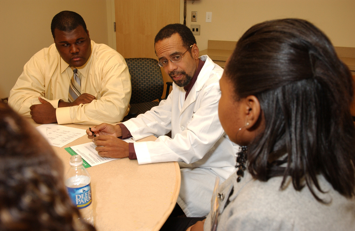 Dr. Keith Hunter, CC anesthesiologist, talks with Howard University students Montreal McMorris (left) and Coretta Tillery (right) who, along with 18 of their fellow classmates, visited the CC as a part of a new mentor-partnership between NIH and the university. 