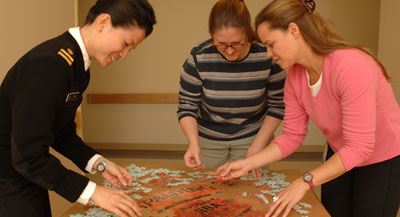 Three people putting together a puzzle