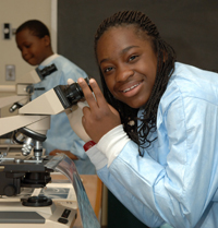 Laetitia looks through a microscope.