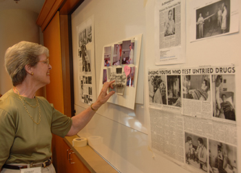 One of the visitors from the faith communities looks at the collections of photos and articles brought by participants in the reunion to share with the group.