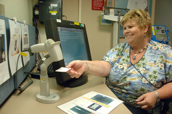 Gail Birmingham, clinical nurse educator in DTM, demonstrates the new touch-screen computer-assisted self-registration for research blood donors.