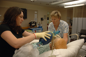 Rose Simpson (left) and Wendy Moore, both clinical research nurses on 3NE, participate in a live-action scenario in the clinical simulation classroom.