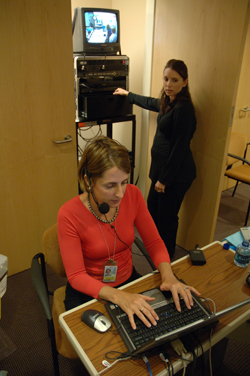 Dr. Amy Agrawal programs the scenario into a computer, which controls the mannequin’s life-like sounds, while Jill Sanko monitors the video feed.