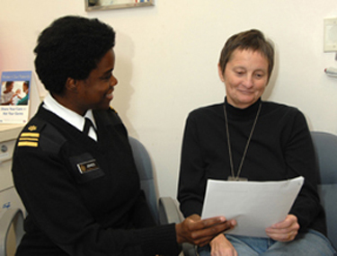 Jacquin Jones, who earned a certificate from the program, talks with a patient.