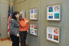 viewers admire art tiles from patient project