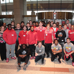 Donna Gregory, Recreational Therapy Chief, poses with football players from the University of Maryland at the Clinical Center North entrance during their visit to the NIH Clinical Center Feb. 27 to inspire patients.