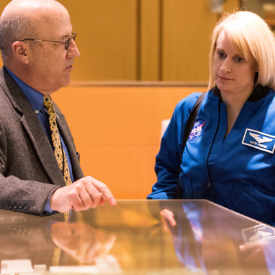 Clinical Center CEO Dr. James Gilman shows NASA astronaut—scientist Dr. Kate Rubins a model of the hospital