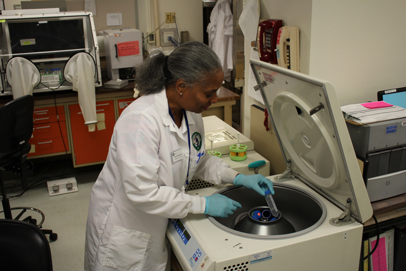 Jessie Bhutani, a clinical laboratory scientist in the Department of Laboratory Medicine, places cultured clinical specimens into an anaerobic chamber during the night shift at the NIH Clinical Center Oct. 7