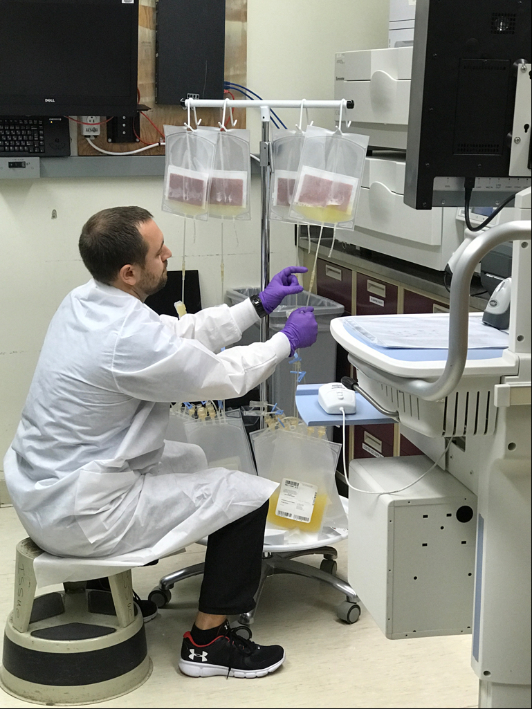 Max Tynuv, with the Department of Transfusion Medicine, separates the platelet component from the Intercept Blood System compound adsorption device during the night shift at the NIH Clinical Center Sept. 28