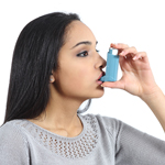 A woman using an asthma inhaler