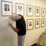 Handyman hangs photo of lasker winners