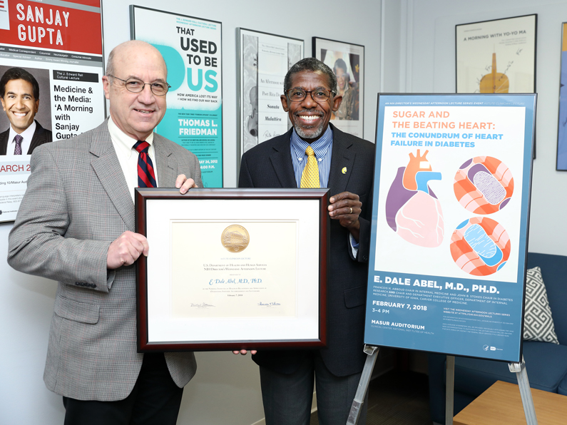 Dr. Jim Gilman, CEO of the Clinical Center, presents a certificate to Dr. E. Dale Abel