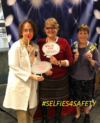 Three women post with props regarding patient safety