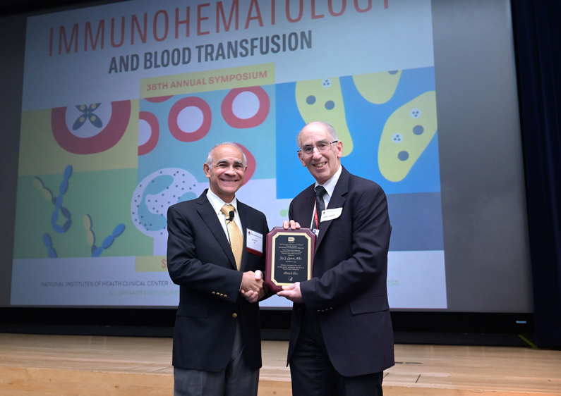 Jay Epstein receives an award from Dr. Harvey G. Klein