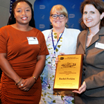 Three women photographed with an award