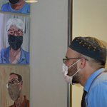 Staff member admires Covid-19 portrait series
