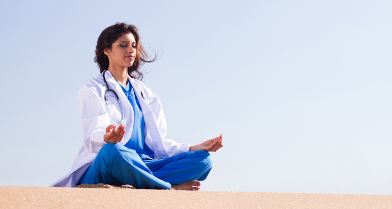 A women in lab coat meditates in a serene environment